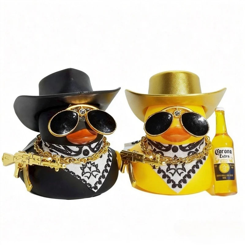 A pair of black and yellow cowboy rubber duck car ornaments with gold accents and a Corona Extra bottle.