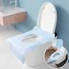A white toilet with light blue disposable seat liners is shown next to a pink sink on a light blue wall.