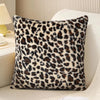 A square plush velvet pillowcase with a brown and black leopard print resting on a light-colored sofa.