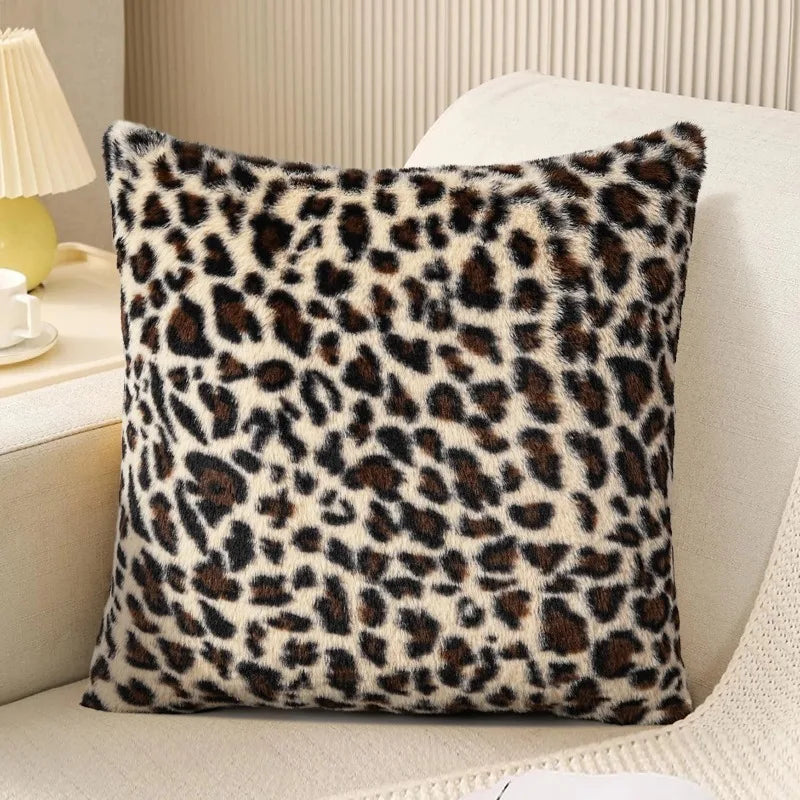 A square plush velvet pillowcase with a brown and black leopard print resting on a light-colored sofa.