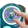 A hand is spinning the rotatable shell part of a teal crawling crab toy.