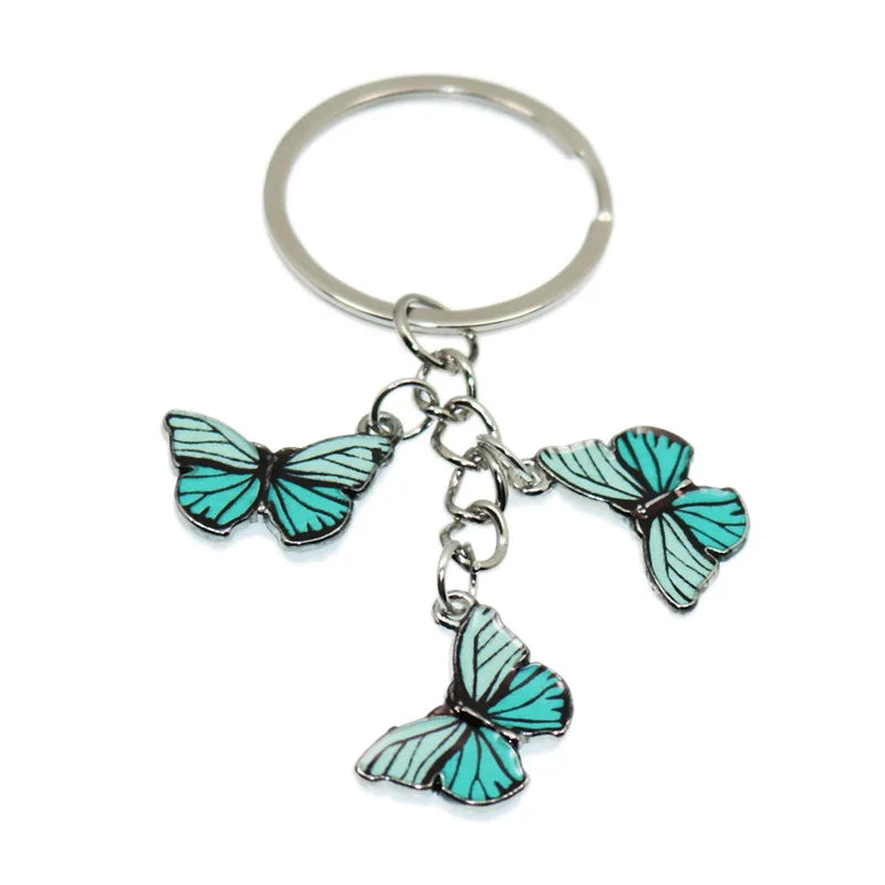 Silver butterfly keychain charm with teal wings