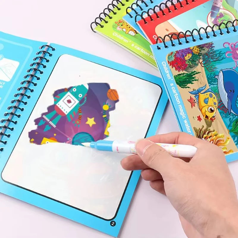 A hand draws a colorful cartoon design in a blue reusable magic water drawing book.