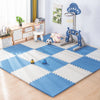 A blue and white interlocking foam play mat with various toys like a basketball and stuffed animals.