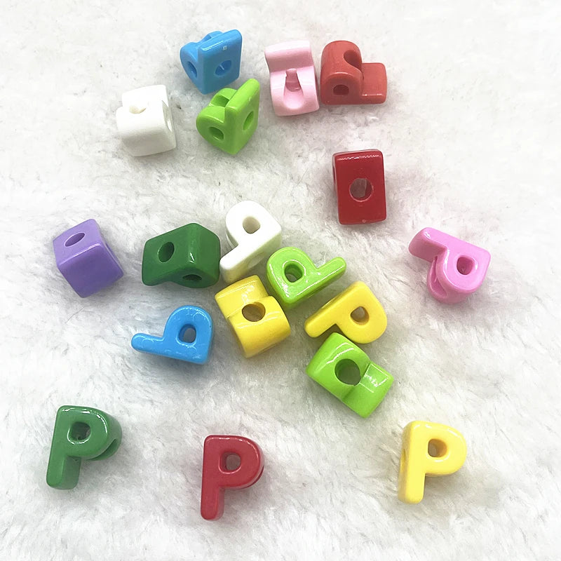 A collection of 10 mixed alphabet letter beads in various colors and shapes scattered on a white surface.