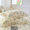 A set of two floral cotton pillowcases featuring green and pink botanical patterns on a white background.