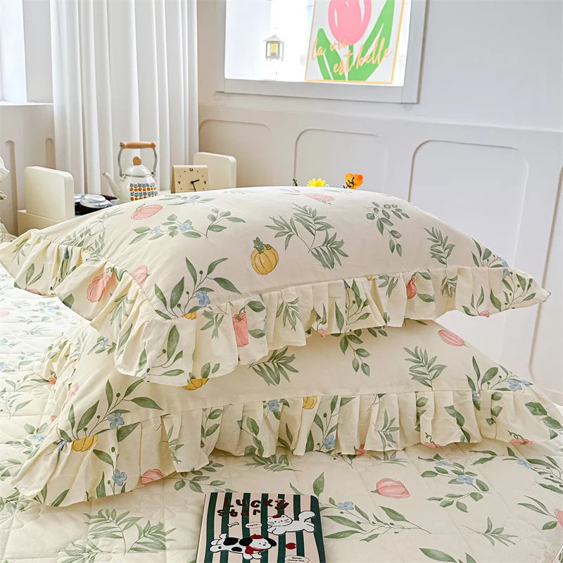 A set of two floral cotton pillowcases featuring green and pink botanical patterns on a white background.