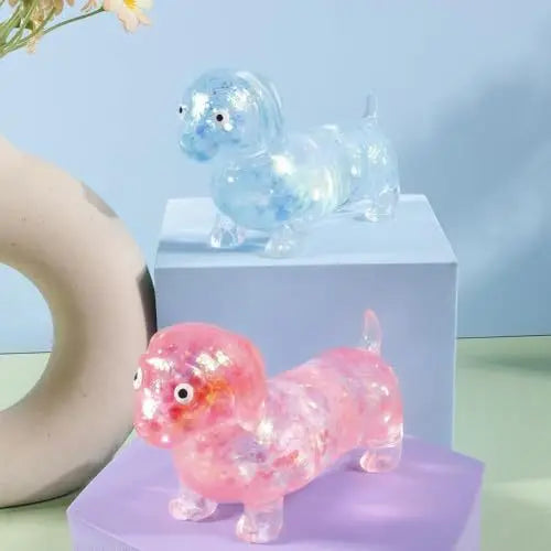 لعبة مضغوطة من داكسهوند وردية لامعة للاسترخاء تستريح على سطح بنفسجي.
