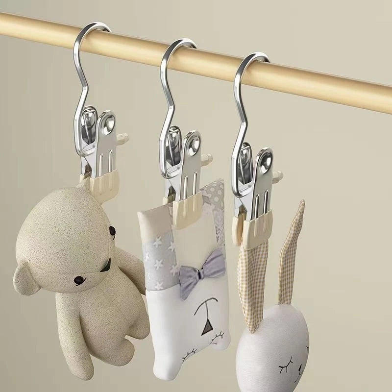 Stainless steel clothespins with hooks hanging from a wooden rod, featuring cute animal-themed grips.
