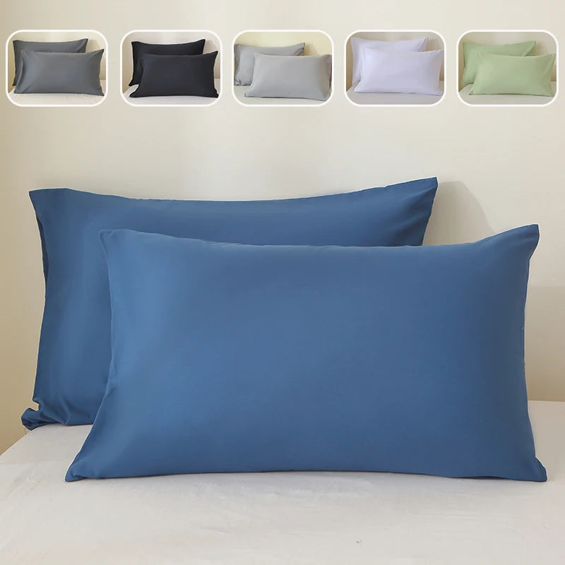 A set of nine pillow covers in various shades of gray, black, white, and green, displayed next to a large blue pillow.