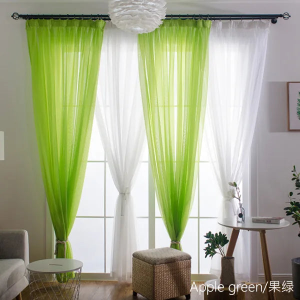 Three panels of sheer lime green and white voile curtains hanging in a window.