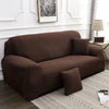 A dark brown silky soft stretchable sofa cover displayed on a light rug in a living room setting.