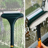 A dark green dual-use window screen and glass cleaning brush is shown cleaning a window pane.