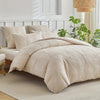 A beige embossed leaf pattern microfiber duvet cover set displayed on a bed with white bedding and natural light.