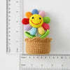 Handcrafted crochet sunflower with colorful petals growing out of a brown crocheted pot