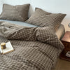 A plaid duvet cover in brown and beige tones with matching pillows on a bed.