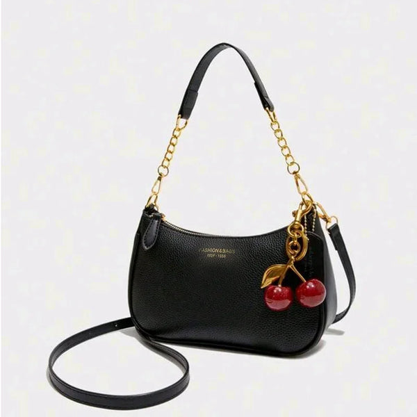 Black leather crossbody bag with a gold chain strap and a tassel detail.