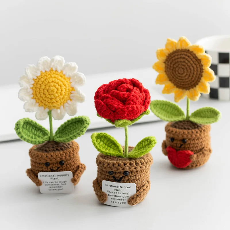 Handmade crochet positive energy plant decor featuring a white daisy, a red rose, and a yellow sunflower.