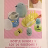 A collection of baby bottle accessories including a silicone bottle, yellow food accessories, and a glass bottle.