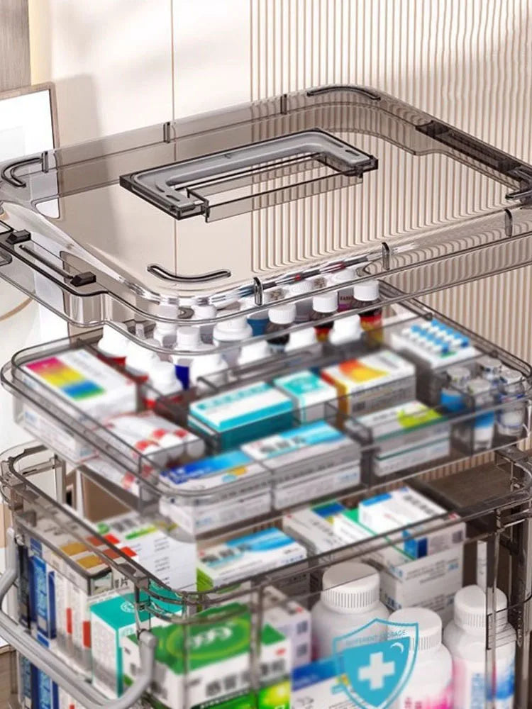 A clear plastic first aid storage box with a handle, showing various medical supplies organized in multiple compartments.