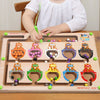 A wooden magnetic color sorting maze board for kids with various colored pegs and a child writing on it.