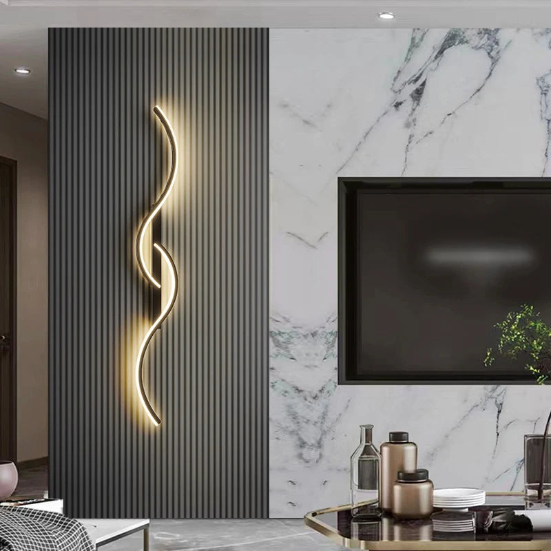 A modern minimalist LED wall lamp with a curved, glowing design mounted on a dark gray vertical panel next to a marble wall a