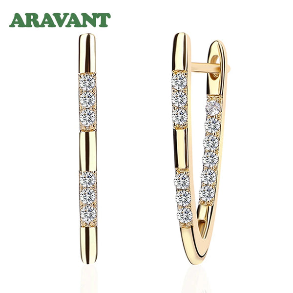 Boucles d'oreilles en anneau dorées avec des pierres claires.