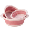 A pink foldable travel wash basin or portable tub with a ribbed design.