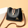 Black women's three-layer leather shoulder bag with a tan crossbody strap on a light background.