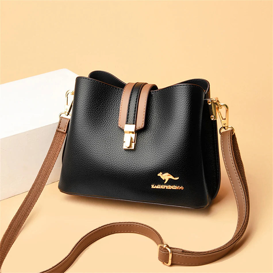 Black women's three-layer leather shoulder bag with a tan crossbody strap on a light background.