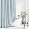 Light blue boho waterproof shower curtain with tassels hanging in a modern bathroom