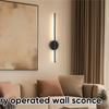 Battery operated wall sconce with remote control and dimmable lighting mounted on a wall.