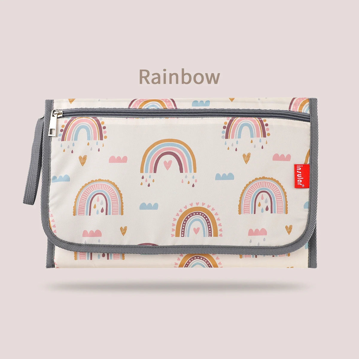 A beige foldable baby changing mat with a waterproof cover and storage bag featuring a rainbow pattern.