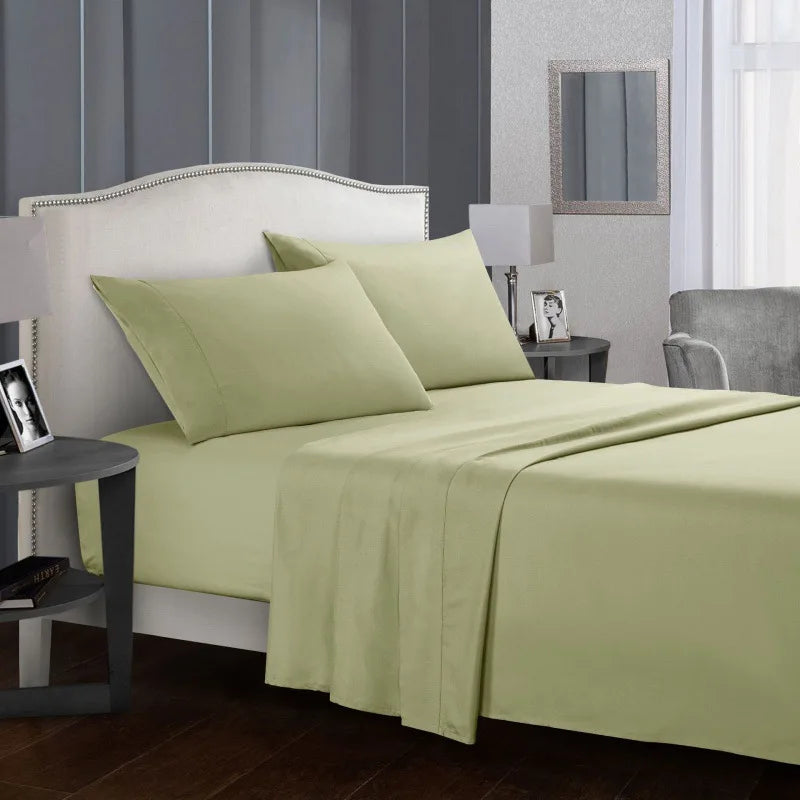 Un lit vert clair avec tête de lit et literie blanche dans une chambre moderne.