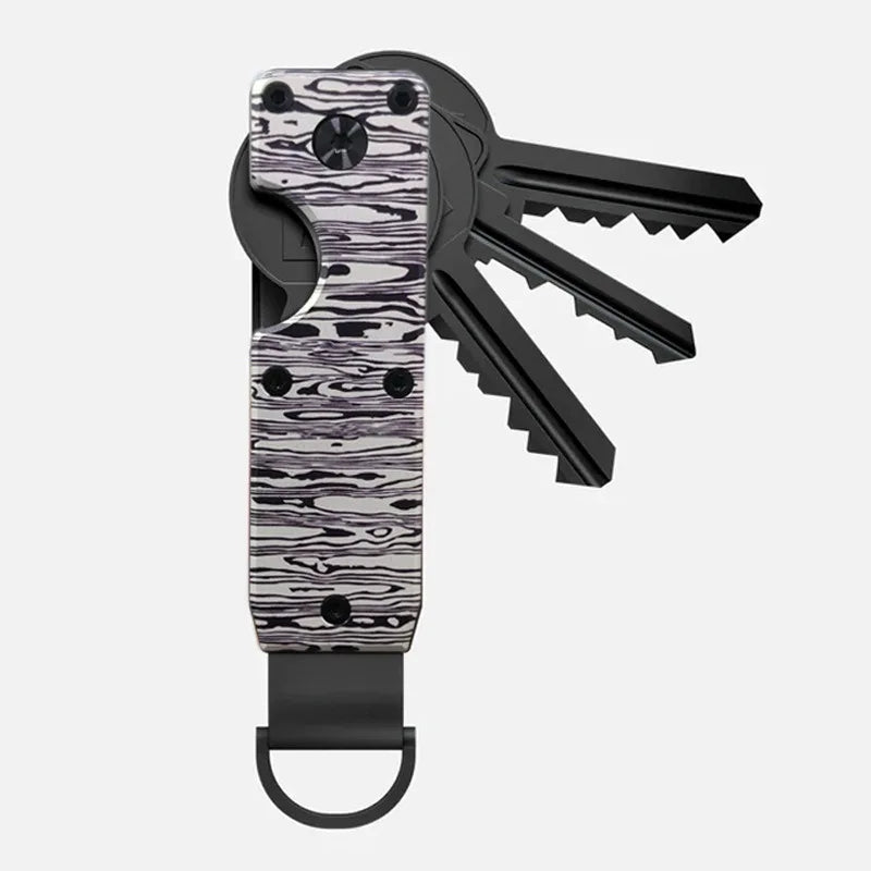 A minimalist aluminum key organizer with a black handle and a metal key attached.