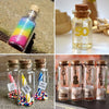 A collection of mini glass bottles with cork stoppers, some filled with colorful glitter and other decorative elements.