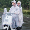 Two people wearing transparent waterproof motorcycle rain ponchos with hoods standing next to a white motorcycle.