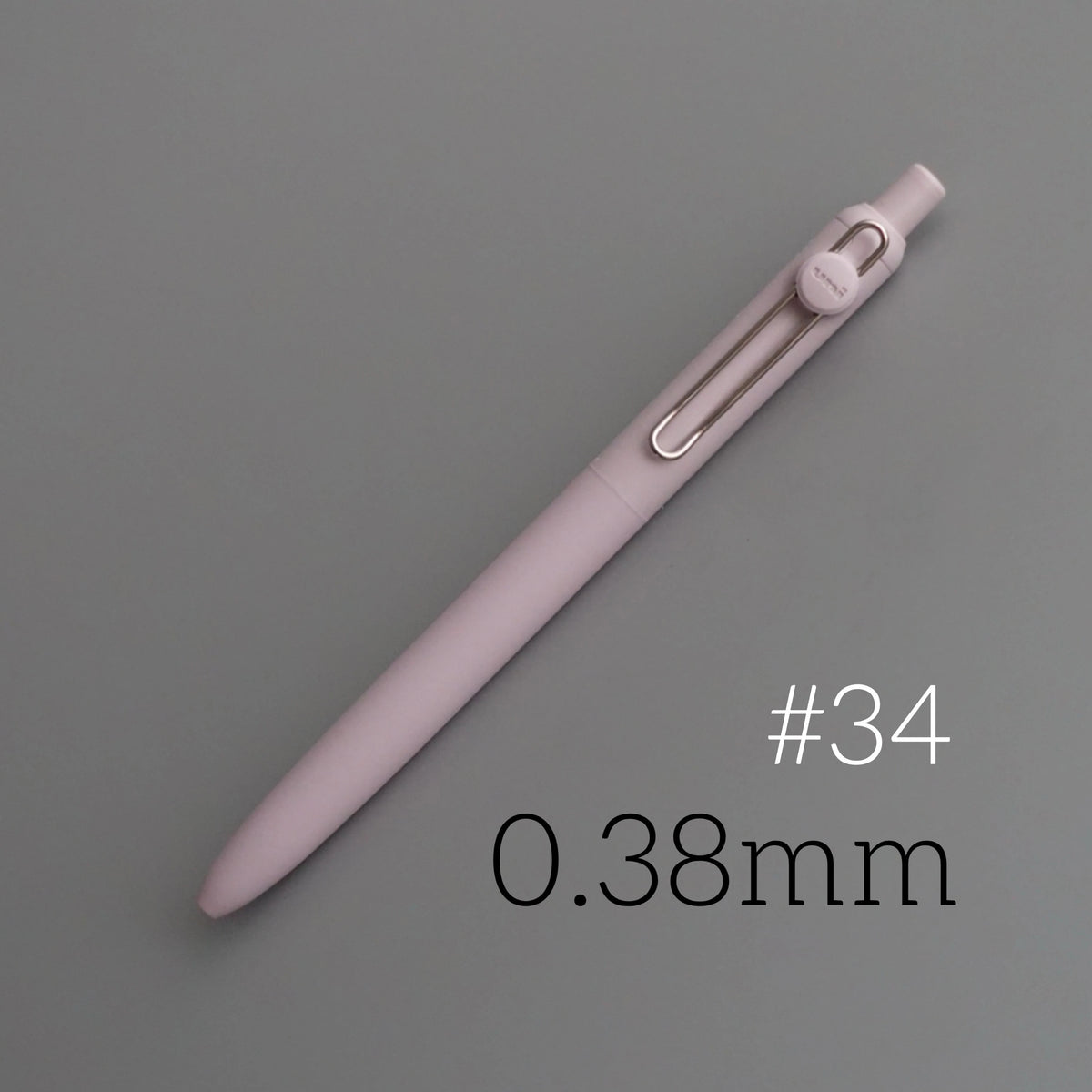 A close-up view of a light pink Uni ZENTO Quick-Dry Gel Pen with a silver clip, shown diagonally on a gray background.
