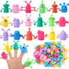 A hand holds a large collection of colorful, cute monster finger fidget toys and toppers.