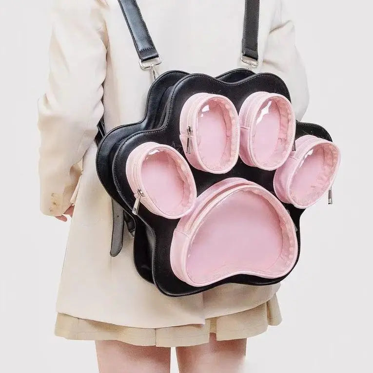 A black backpack with pink lining and multiple pockets shaped like cat paw prints, worn by a person.