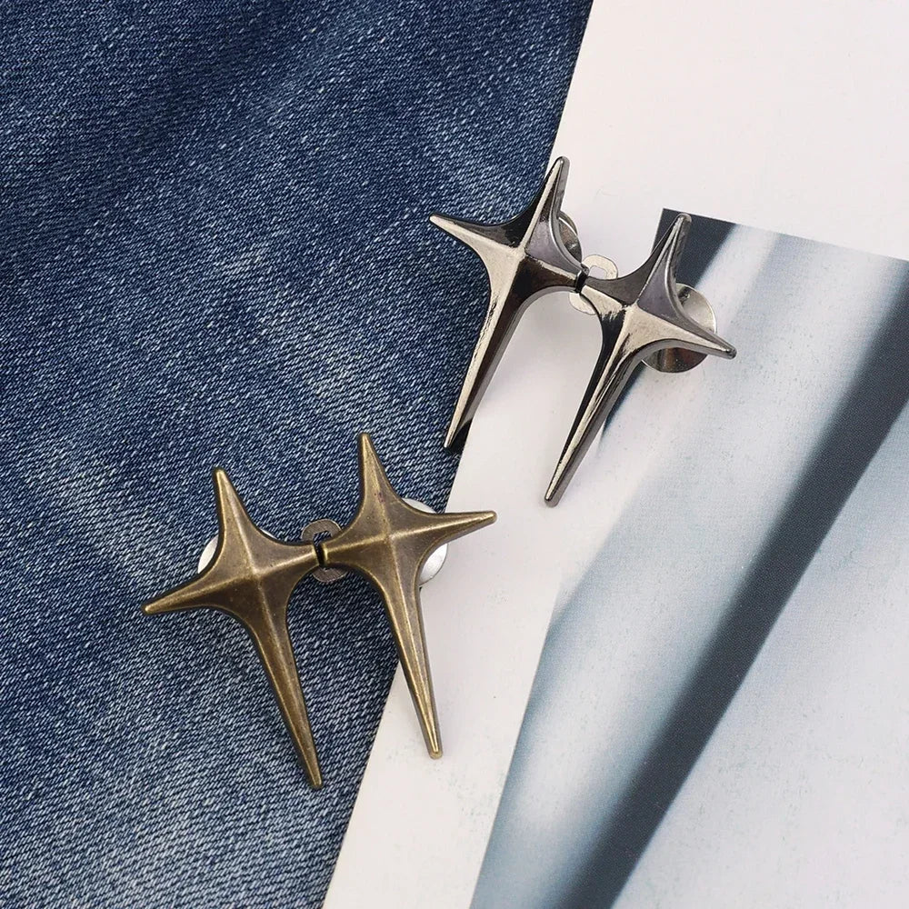 Two gold-toned Y2K star waist tightener clips for jeans resting on a white surface.