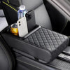 A black car center console armrest cushion with a diamond pattern and integrated cup holders holds a smartphone and a water b