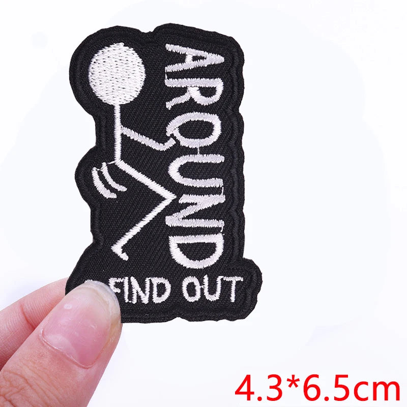 Black embroidered iron-on letter patch with the text AROUND FIND OUT on a white background