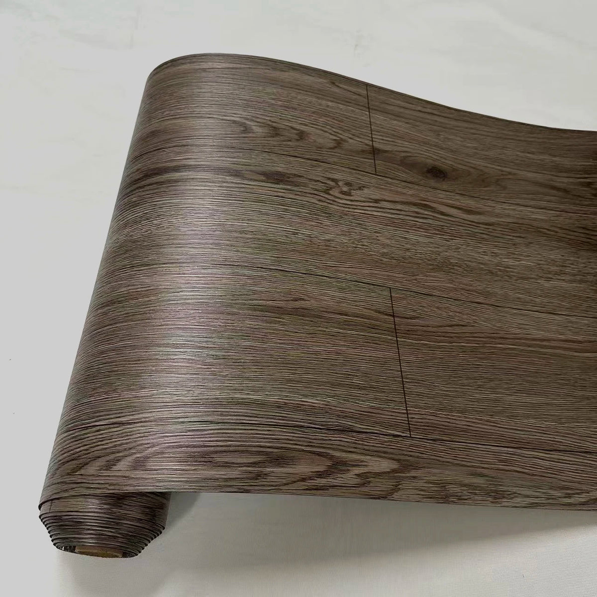 A close-up view of a brown wood grain PVC self-adhesive decal roll.
