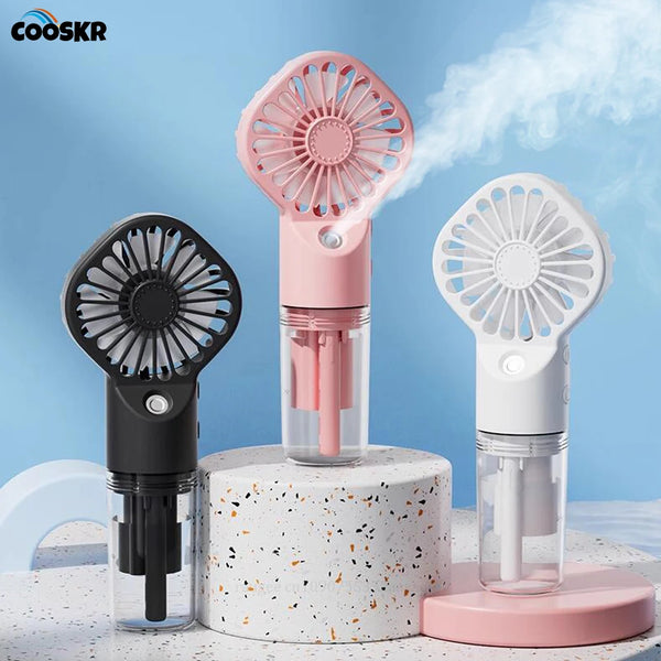 Un ventilador de niebla portátil rosa y blanco en un soporte redondo blanco.