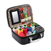 A black leather sewing kit box with a leopard print lining, containing various needles and tools.