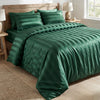 A dark emerald green satin striped jacquard duvet cover set displayed on a bed with natural wood accents.