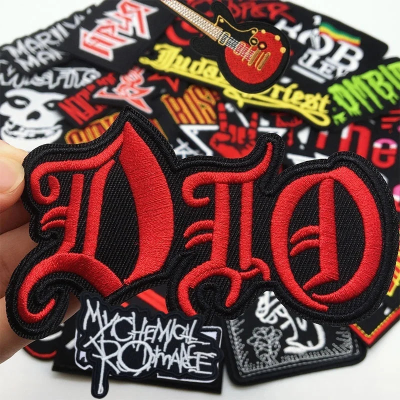 A set of embroidered iron-on patches featuring the acronym DIO in red and black on a black fabric background.