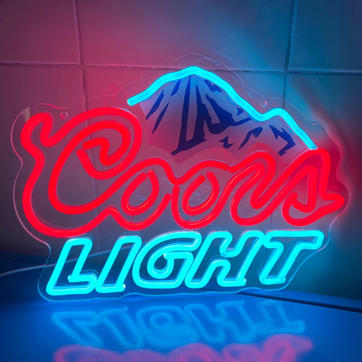 LED neon sign featuring a mountain logo and the words COOLS LIGHT glowing in blue and red.