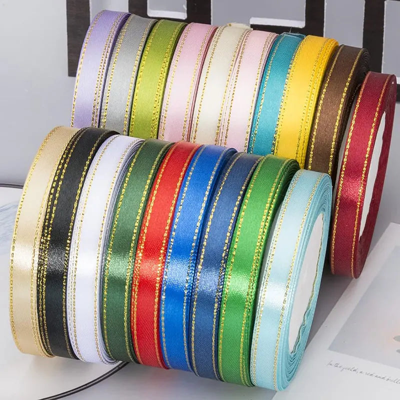 A collection of gold-edge satin ribbons in various colors including green, pink, yellow, blue, and red.